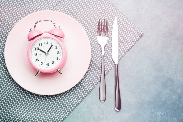 Clock and balanced meal illustrating a 24-hour fast